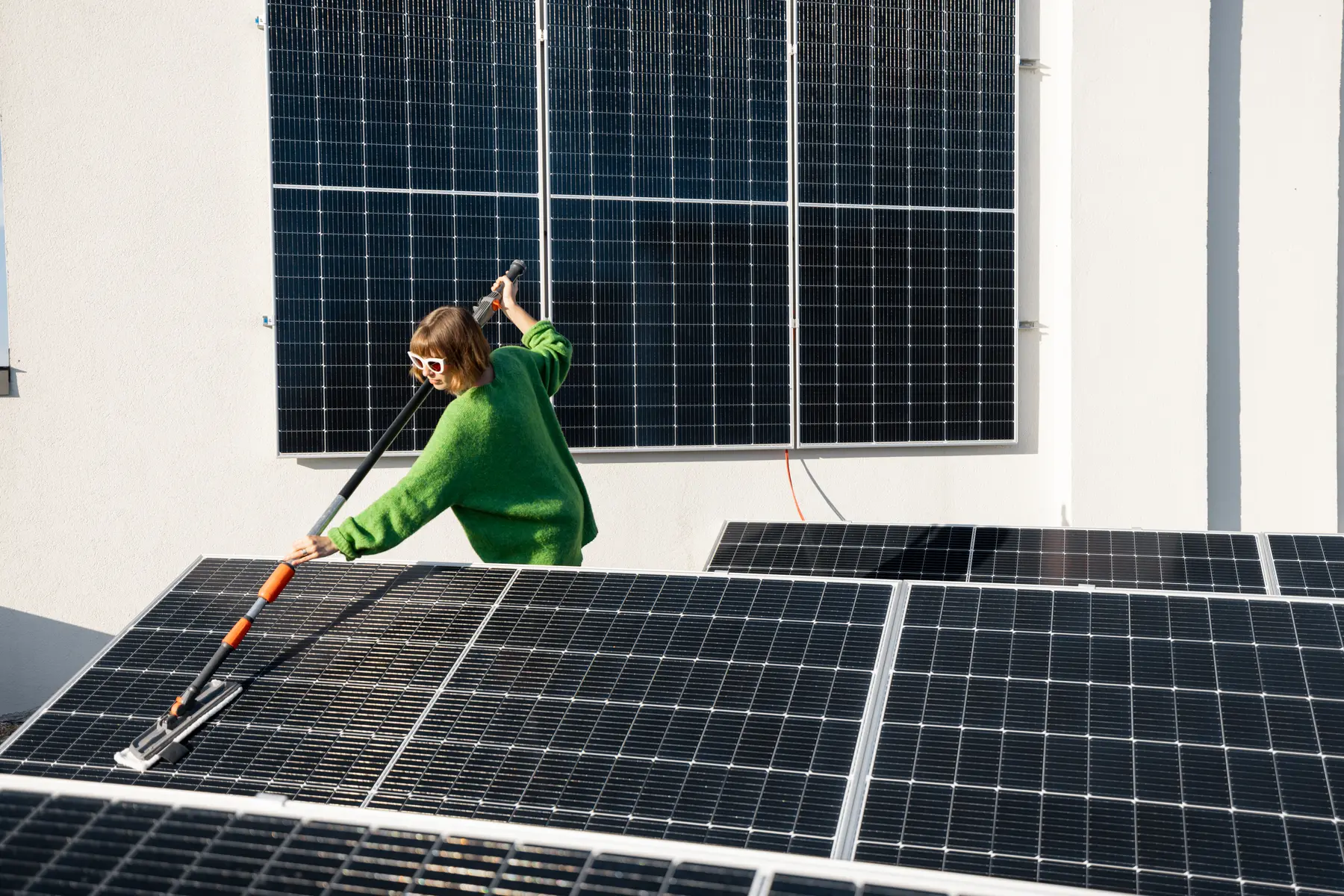 Limpieza con pértiga de las placas solares de una vivienda, en la terraza y en la fachada